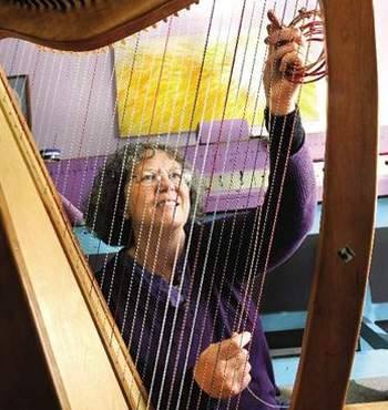 Markwood Heavenly Strings & Cases proprietor Laurie Nielsen strings a harp